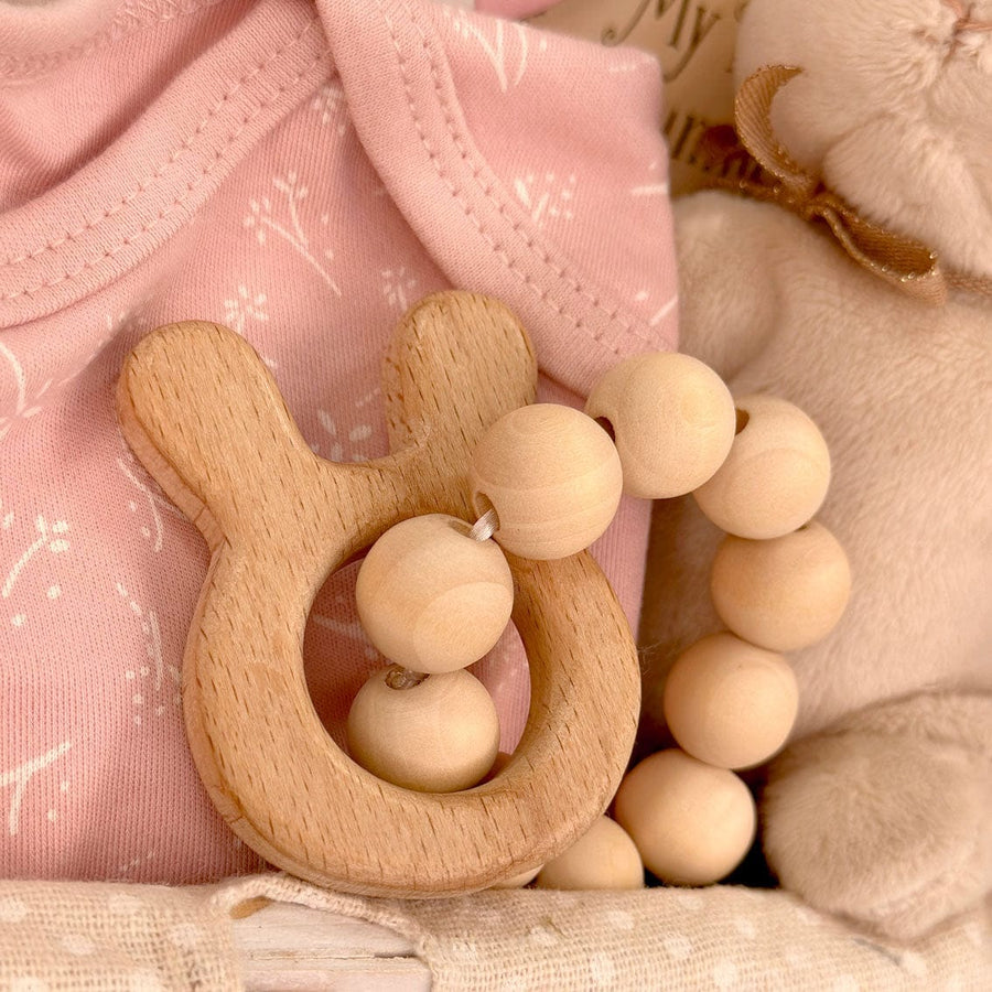 A pink Deluxe Baby Gift Hamper teddy bear, a wooden tooth brush, and a Deluxe Baby Gift Hamper teddy bear in a basket. (Brand: VWOWGIFTS)