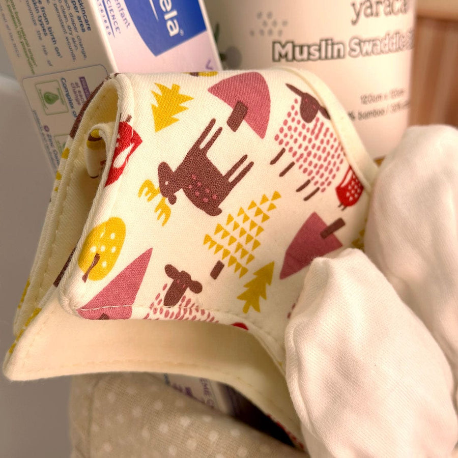 A VWOWGIFTS Deluxe Baby Gift Hamper is sitting on top of a cloth.