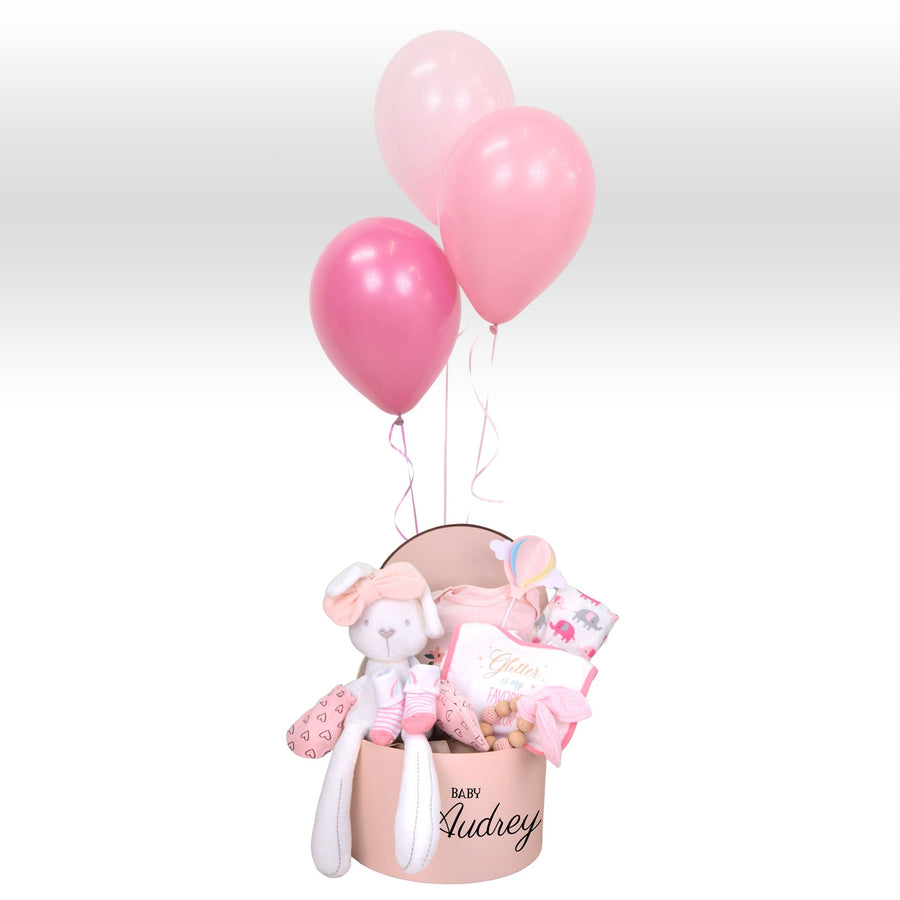 A pink VWOWGIFTS gift box with a Baby Girl Hamper featuring a Hot Air Balloon of Love and a teddy bear.