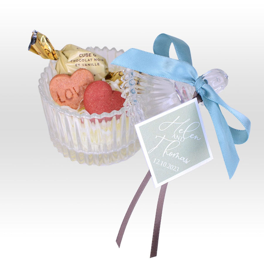 A PURE DELIGHT WEDDING FAVOUR WITH CRYSTAL GLASSWARE BOX-HANDMADE HEART SHAPE COOKIES & CHOCOLATE by VWOWGIFTS in a clear container with a blue ribbon.