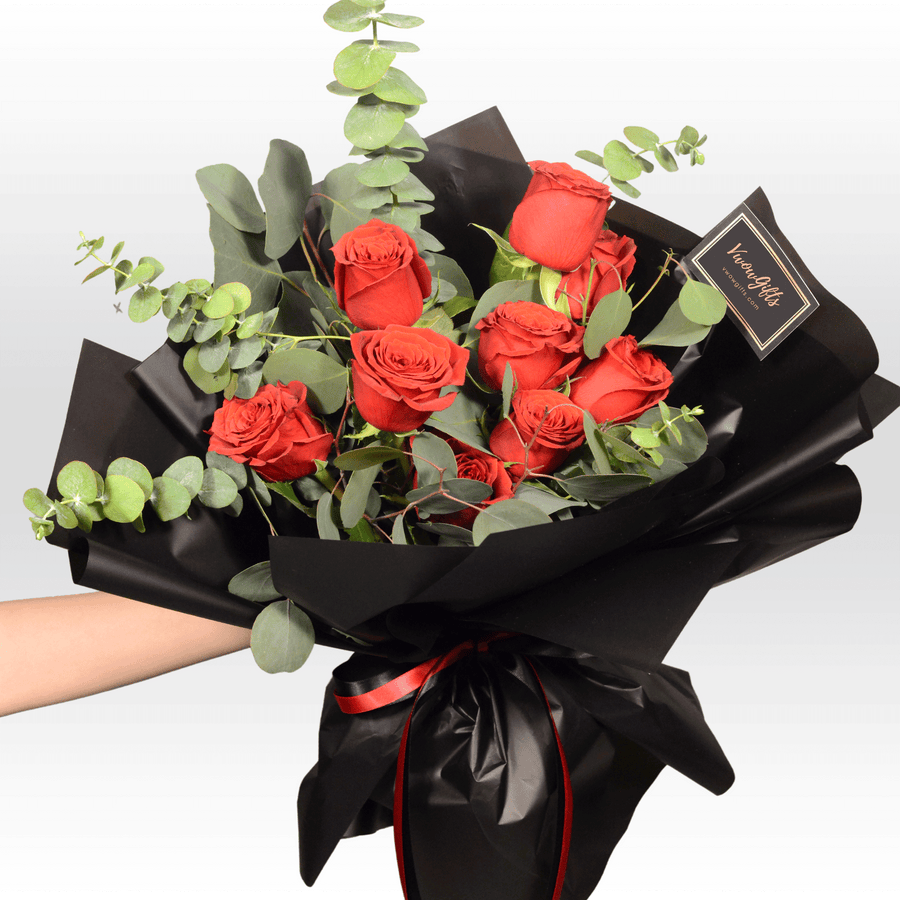 A person is holding a bouquet of VWOWGIFTS' ROSE WHISPERER red roses.