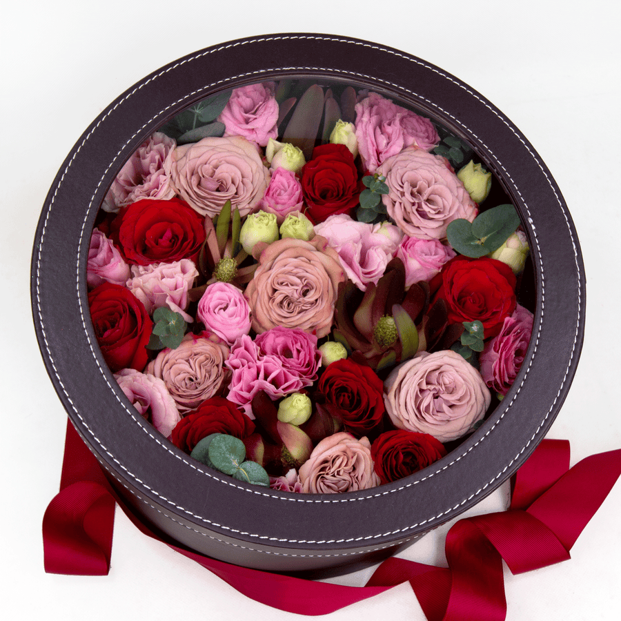 A round box filled with pink and red WHISPERING LOVE roses by VWOWGIFTS.