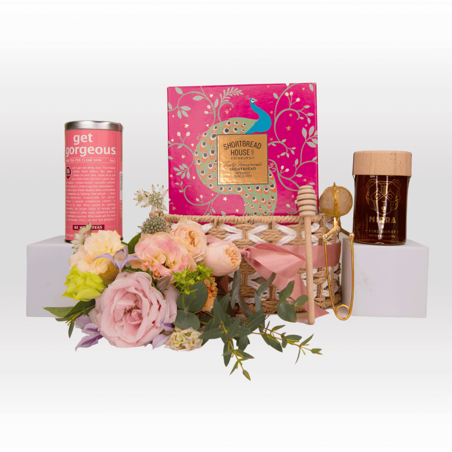 A VWOWGIFTS gift basket with MODERN ROMANTICS flowers and a box of tea.