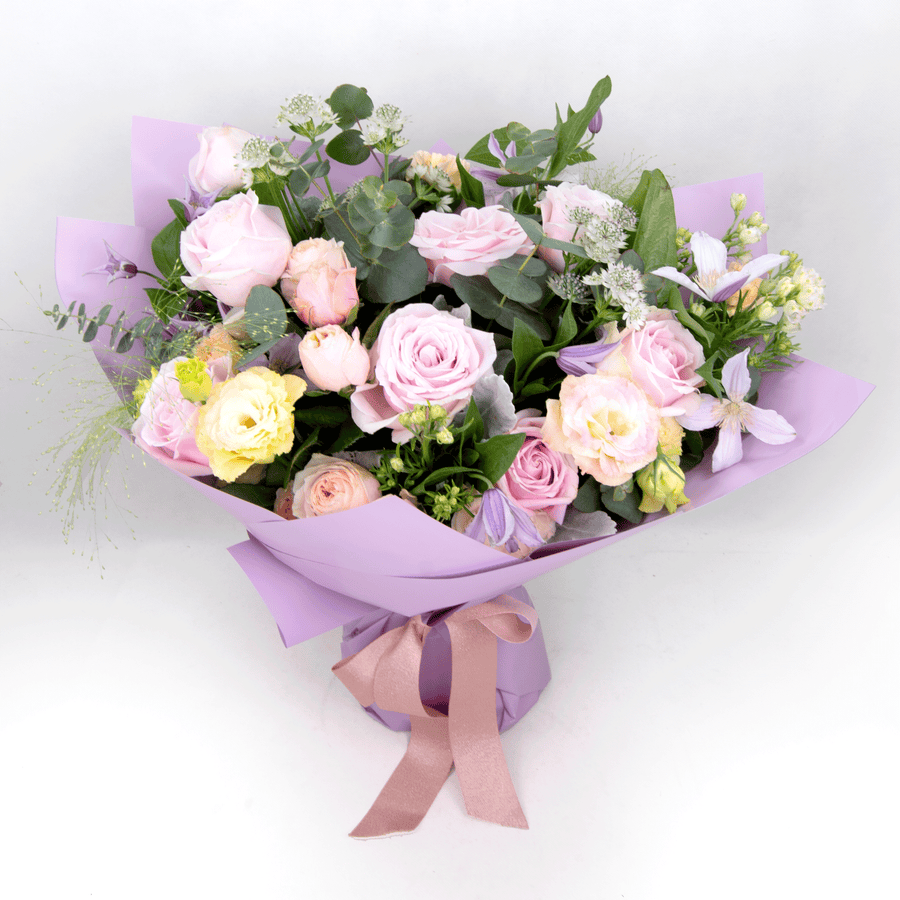 A bouquet of JUST FOR YOU pink roses wrapped in purple paper, from the brand VWOWGIFTS.