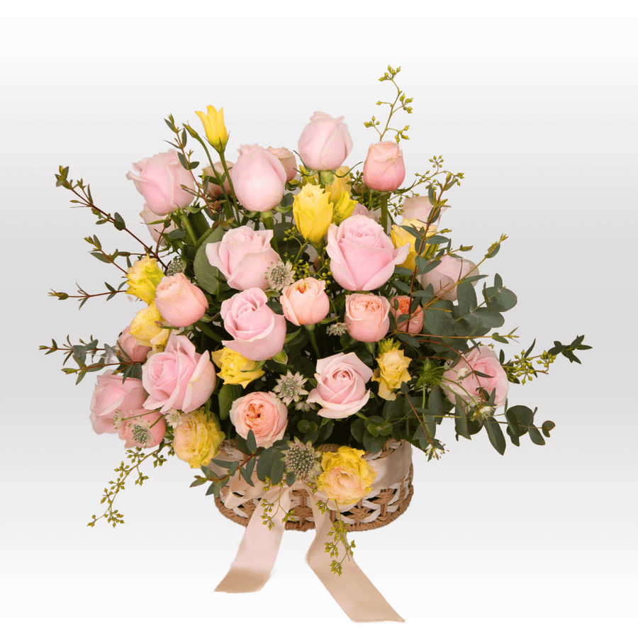 A basket filled with VWOWGIFTS SWEET VIBES pink and yellow roses.