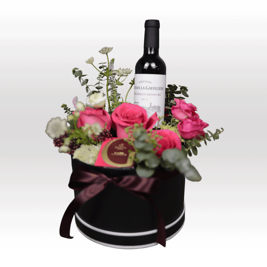 A black box filled with SUNRIT FLOWER GIFT SET flowers and a bottle of VWOWGIFTS wine.