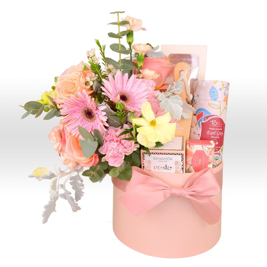 A pink SKINCARE RADIANCE FLOWER GIFT BOX from VWOWGIFTS filled with flowers and a bow.