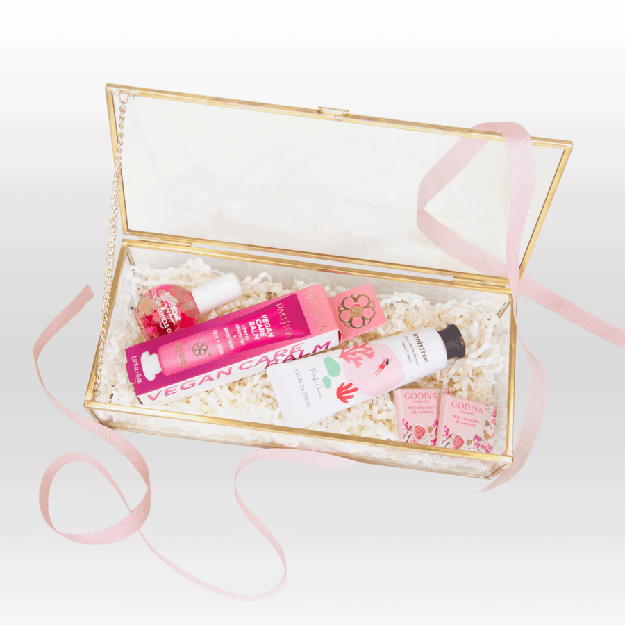 A pink gift box with RELAX & RECHARGE cosmetics and a pink ribbon by VWOWGIFTS.