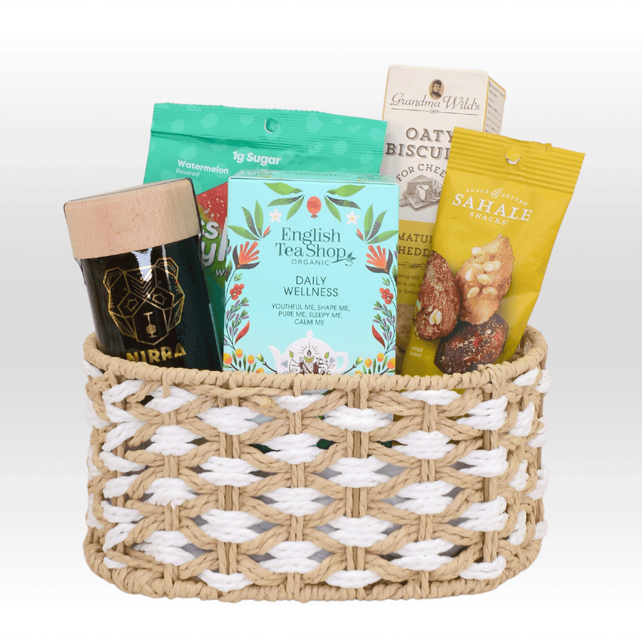 A WEEKEND LEISURE wicker basket with a variety of snacks in it, by VWOWGIFTS.